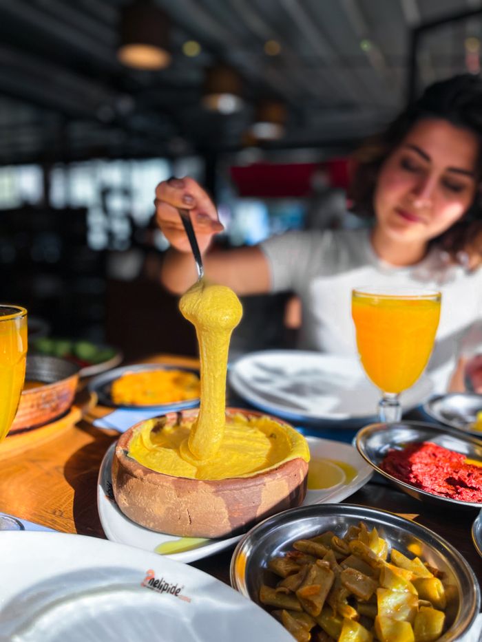 A woman enjoys a traditional Turkish meal in a cozy restaurant setting, showcasing local flavors.